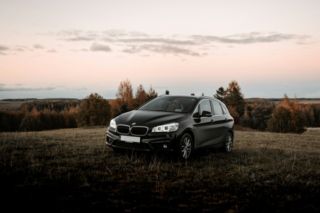 black mercedes benz c class on brown grass field during daytime